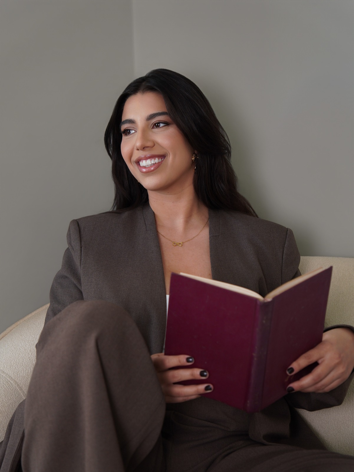 Lorena Cirino, psicóloga clínica, com um livro nas mãos em ambiente acolhedor